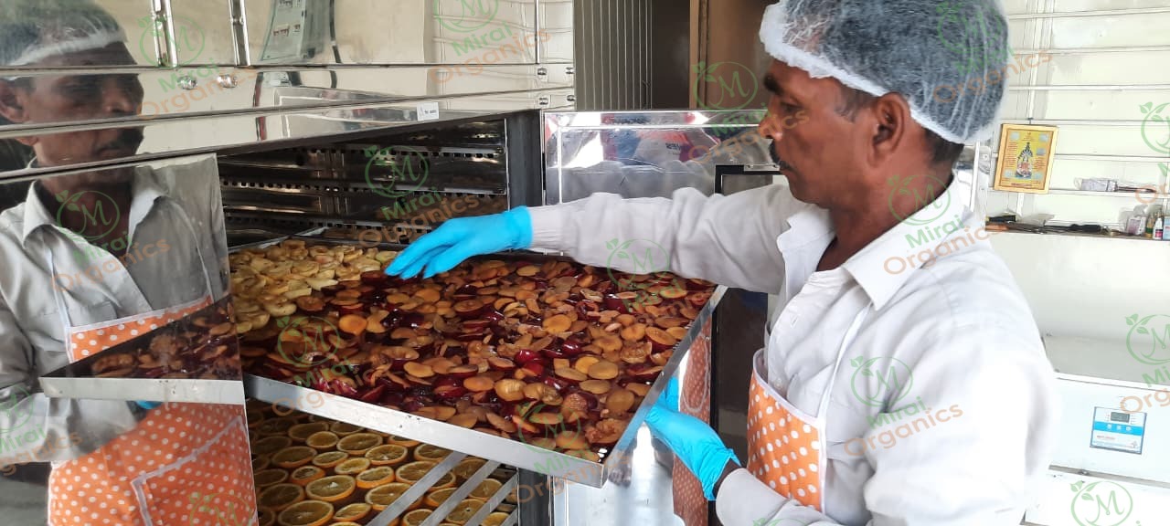 Trays of dried orange and stone-fruit slices being loaded into a dehydrator at the Mirai Organics facility